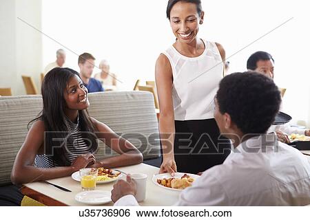 Stock Photograph - Waitress Serving Couple Breakfast In Hotel Restaurant. Fotosearch