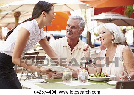 Waitress Serving Senior Couple Lunch In Outdoor Restaurant View Large Photo Image Picture - Waitress Serving Senior Couple Lunch In Outdoor Restaurant. Fotosearch