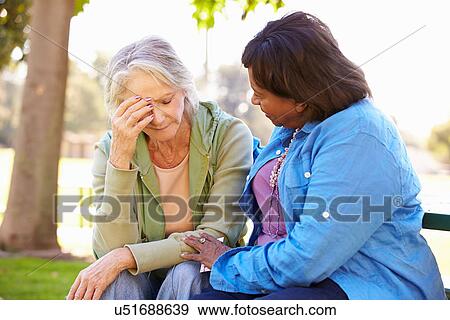 Woman Comforting Unhappy Senior Friend Outdoors View Large Photo Image Stock Photo - Woman Comforting Unhappy Senior Friend Outdoors. Fotosearch