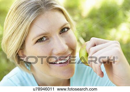 Woman eating apple outdoors View Large Photo Image Stock Image - Woman eating apple outdoors. Fotosearch