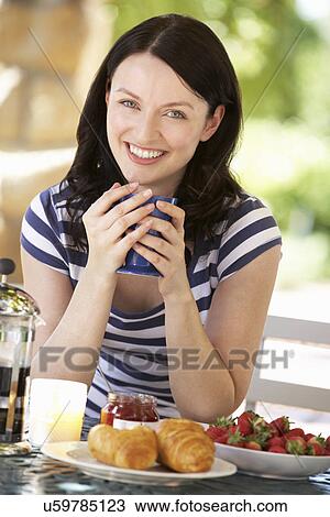 Woman eating breakfast outdoors View Large Photo Image Stock Image - Woman eating breakfast outdoors. Fotosearch