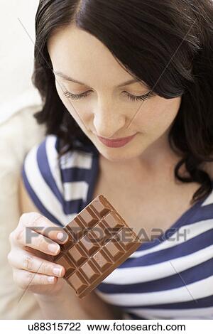 Stock Image - Woman eating chocolate. Fotosearch