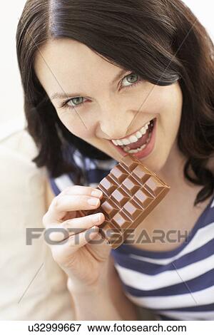 Stock Photo - Woman eating chocolate. Fotosearch