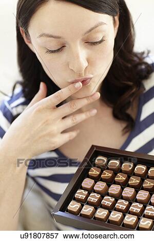 Woman eating chocolates View Large Photo Image Stock Photo - Woman eating chocolates. Fotosearch