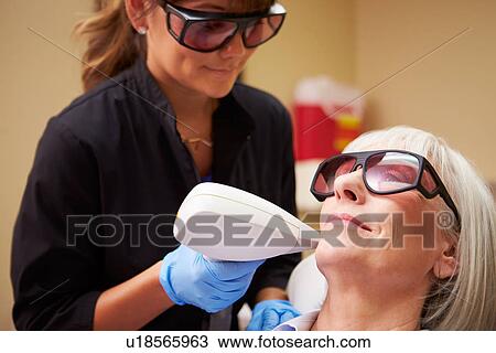 Stock Image - Woman Having Laser Treatment At Beauty Clinic. Fotosearch