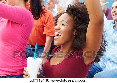 Stock Photograph - Woman In Crowd Celebrating At Sports Event. Fotosearch