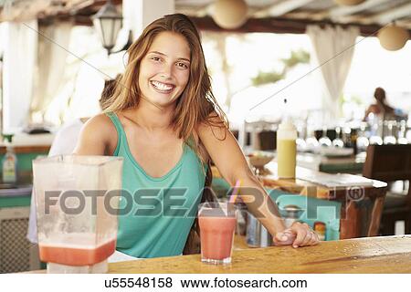 Stock Photo - Woman In Restaurant Making Fruit Smoothies. Fotosearch