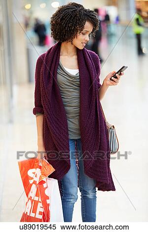 Woman In Shopping Mall Using Mobile Phone View Large Photo Image Stock Photography - Woman In Shopping Mall Using Mobile Phone. Fotosearch