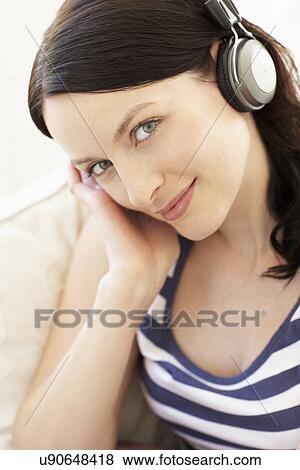 Woman listening to music through headphones View Large Photo Image Stock Photo - Woman listening to music through headphones. Fotosearch