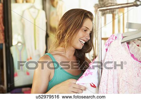 Woman Looking At Clothes On Rail In Store View Large Photo Image Stock Photograph - Woman Looking At Clothes On Rail In Store. Fotosearch