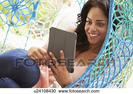 Woman On Outdoor Garden Swing Seat Using Digital Tablet View Large Photo Image Stock Image - Woman On Outdoor Garden Swing Seat Using Digital Tablet. Fotosearch