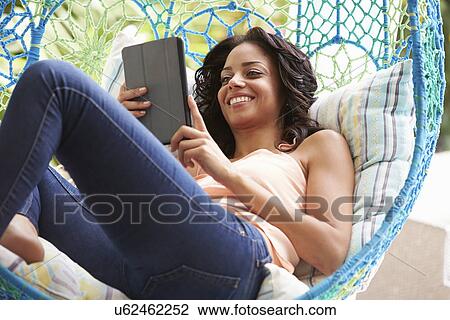 Woman On Outdoor Garden Swing Seat Using Digital Tablet View Large Photo Image Stock Image - Woman On Outdoor Garden Swing Seat Using Digital Tablet. Fotosearch