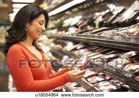 Picture - Woman shopping in supermarket. Fotosearch