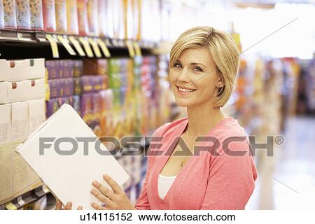 Stock Image - Woman shopping in supermarket. Fotosearch