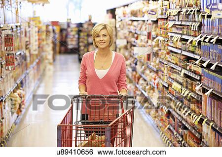 Woman shopping in supermarket View Large Photo Image Stock Photograph - Woman shopping in supermarket. Fotosearch
