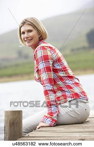 Woman sitting on a jetty View Large Photo Image Stock Image - Woman sitting on a jetty. Fotosearch