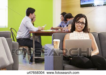 Picture - Woman Sitting On Sofa And Working In Design Studio . Fotosearch