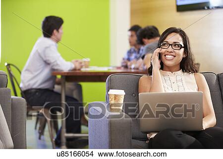 Woman Sitting On Sofa And Working In Design Studio View Large Photo Image Picture - Woman Sitting On Sofa And Working In Design Studio . Fotosearch
