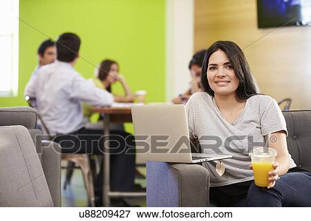 Stock Photo - Woman Sitting On Sofa And Working In Design Studio . Fotosearch