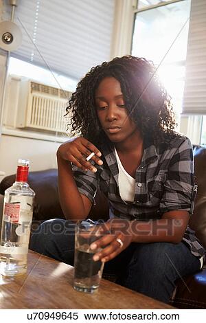Woman Sitting On Sofa With Bottle Of Vodka And Cigarettes View Large Photo Image Stock Photography - Woman Sitting On Sofa With Bottle Of Vodka And Cigarettes. Fotosearch