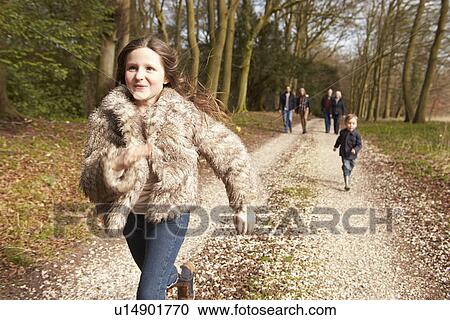 Stock Image - Woman Taking Dog For Walk On City Street. Fotosearch