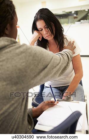 Stock Image - Woman Talking To Counsellor Who Takes Notes. Fotosearch
