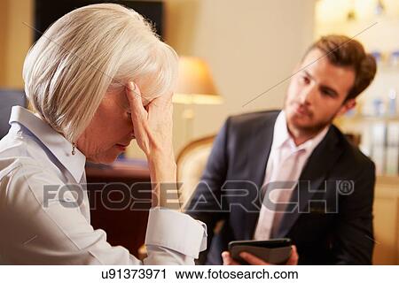 Stock Image - Woman Talking To Male Counsellor Using Digital Tablet. Fotosearch