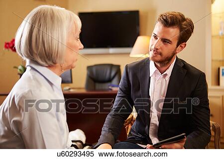 Stock Photography - Woman Talking To Male Counsellor Using Digital Tablet. Fotosearch