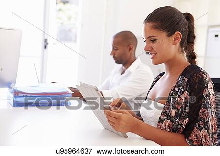 Stock Photo - Woman Using Digital Tablet In Office Of Start Up Business. Fotosearch