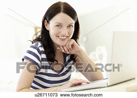 Woman using laptop at home View Large Photo Image Stock Image - Woman using laptop at home. Fotosearch