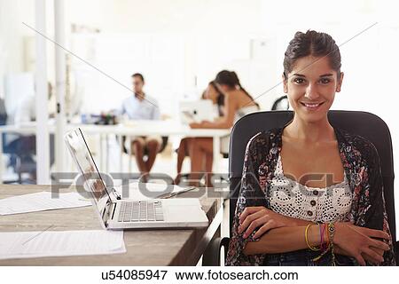 Stock Photo - Woman Using Laptop In Modern Office Of Start Up Business. Fotosearch