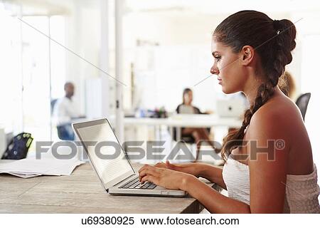Stock Photography - Woman Using Laptop In Modern Office Of Start Up Business. Fotosearch