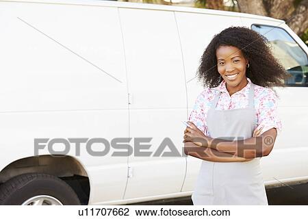 Stock Image - Woman Wearing Apron Standing In Front Of Van. Fotosearch