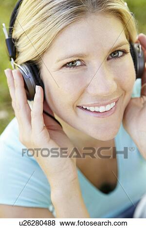 Stock Photo - Woman wearing headphones outdoors. Fotosearch