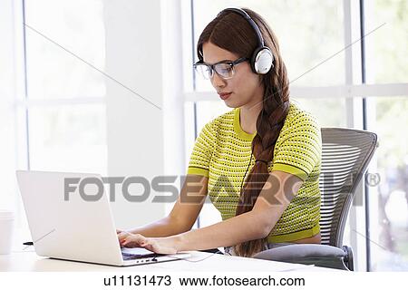 Woman Wearing Headphones Working In Design Studio View Large Photo Image Stock Image - Woman Wearing Headphones Working In Design Studio. Fotosearch