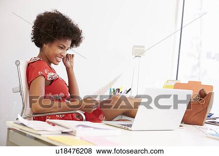 Stock Photo - Woman Working At Desk In Design Studio . Fotosearch