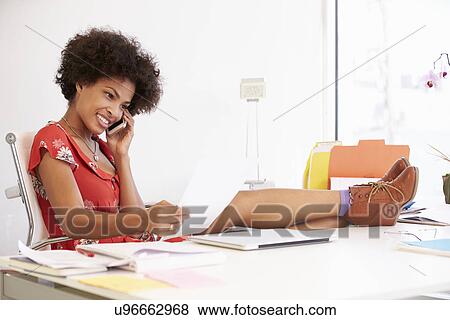 Stock Photo - Woman Working At Desk In Design Studio . Fotosearch