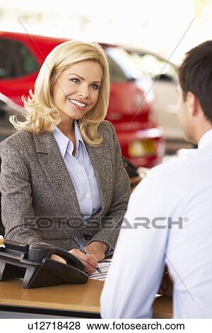 Stock Photo - Woman working in car showroom. Fotosearch