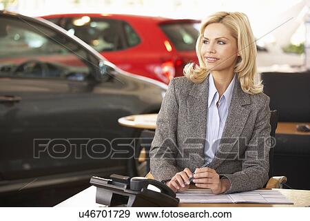 Stock Photo - Woman working in car showroom. Fotosearch
