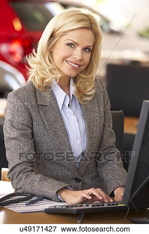 Woman working in car showroom View Large Photo Image Stock Photo - Woman working in car showroom. Fotosearch