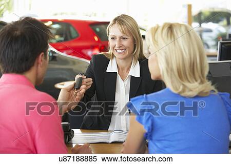 Stock Photography - Woman working in car showroom. Fotosearch