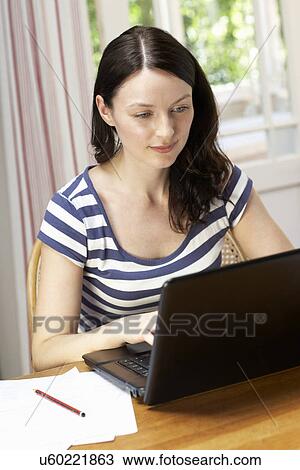 Stock Image - Woman working in home office. Fotosearch