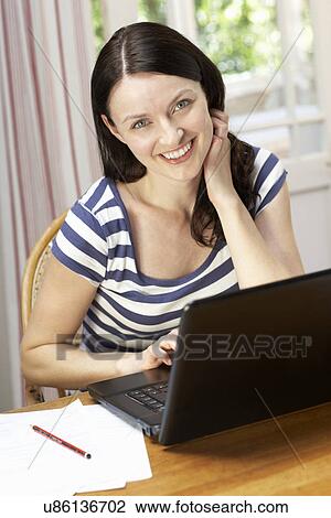 Stock Image - Woman working in home office. Fotosearch