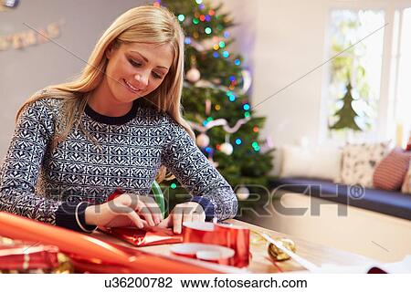 Woman Wrapping Christmas Gifts At Home View Large Photo Image Stock Image - Woman Wrapping Christmas Gifts At Home. Fotosearch
