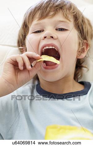 Picture - Young boy eating crisps. Fotosearch