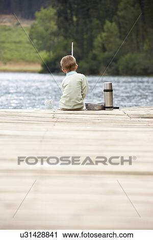Young boy fishing on a jetty View Large Photo Image Stock Image - Young boy fishing on a jetty. Fotosearch