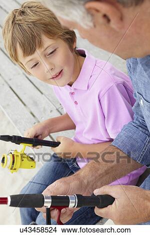 Picture - Young boy fishing with grandfather. Fotosearch