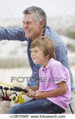 Young boy fishing with grandfather View Large Photo Image Stock Image - Young boy fishing with grandfather. Fotosearch