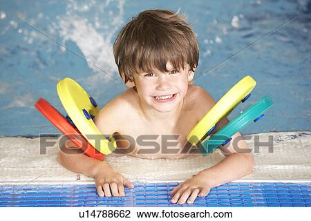 Stock Image - Young boy in swimming pool. Fotosearch