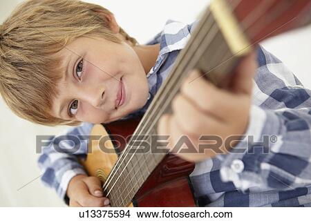 Young boy playing acoustic guitar View Large Photo Image Picture - Young boy playing acoustic guitar. Fotosearch
